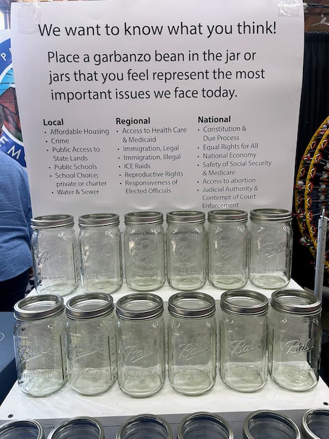A group of mason jars that will be labeled with issues from the poster. Fair attendees will drop garbanzo beans in the jars that represent issues important to them.